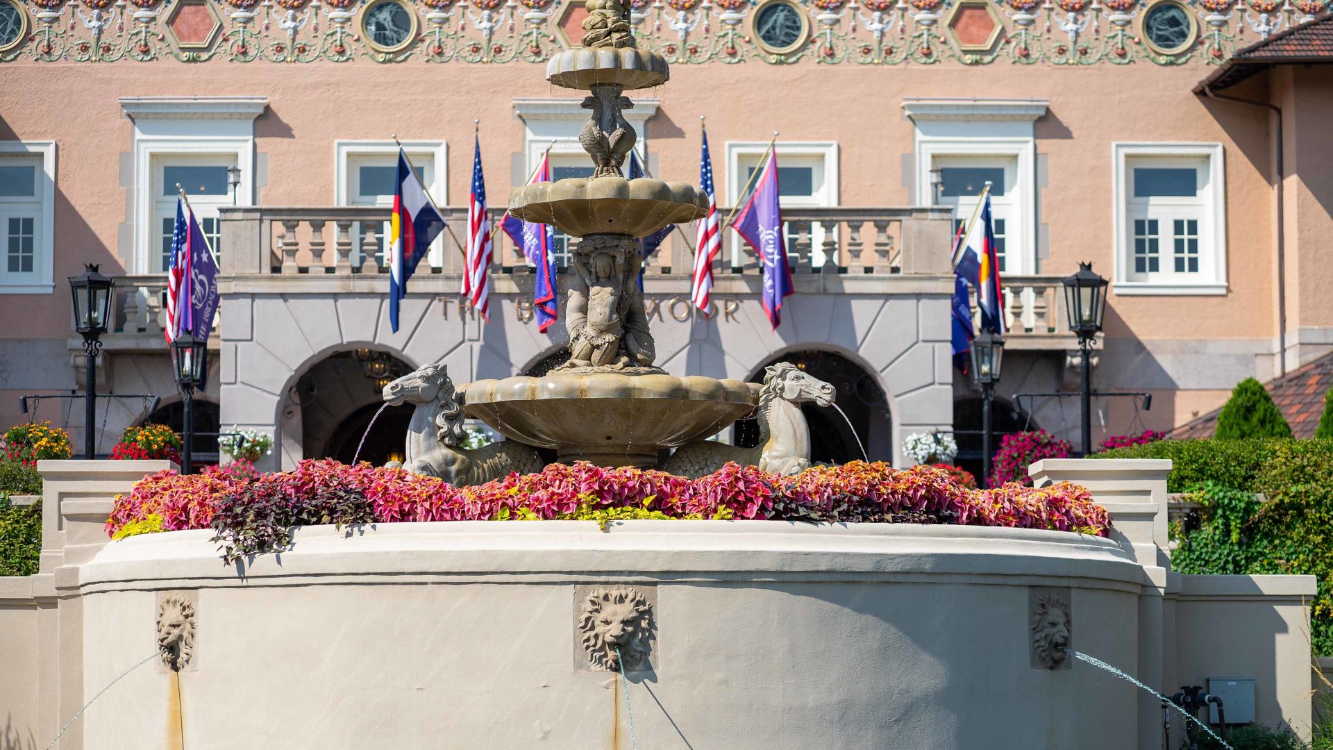 A Fountain With Flowers In Front Of A Building