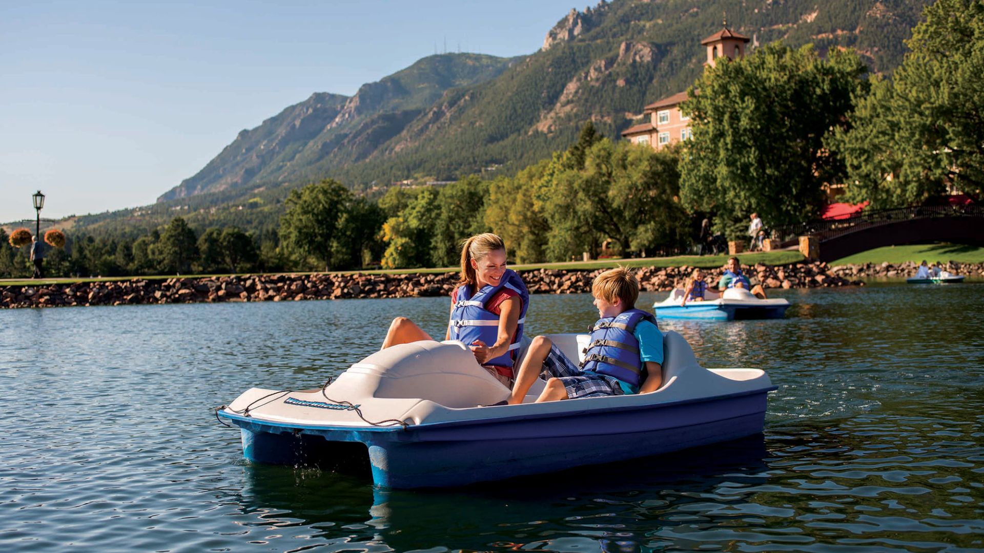 A Group Of People Riding On The Back Of A Boat In The Water