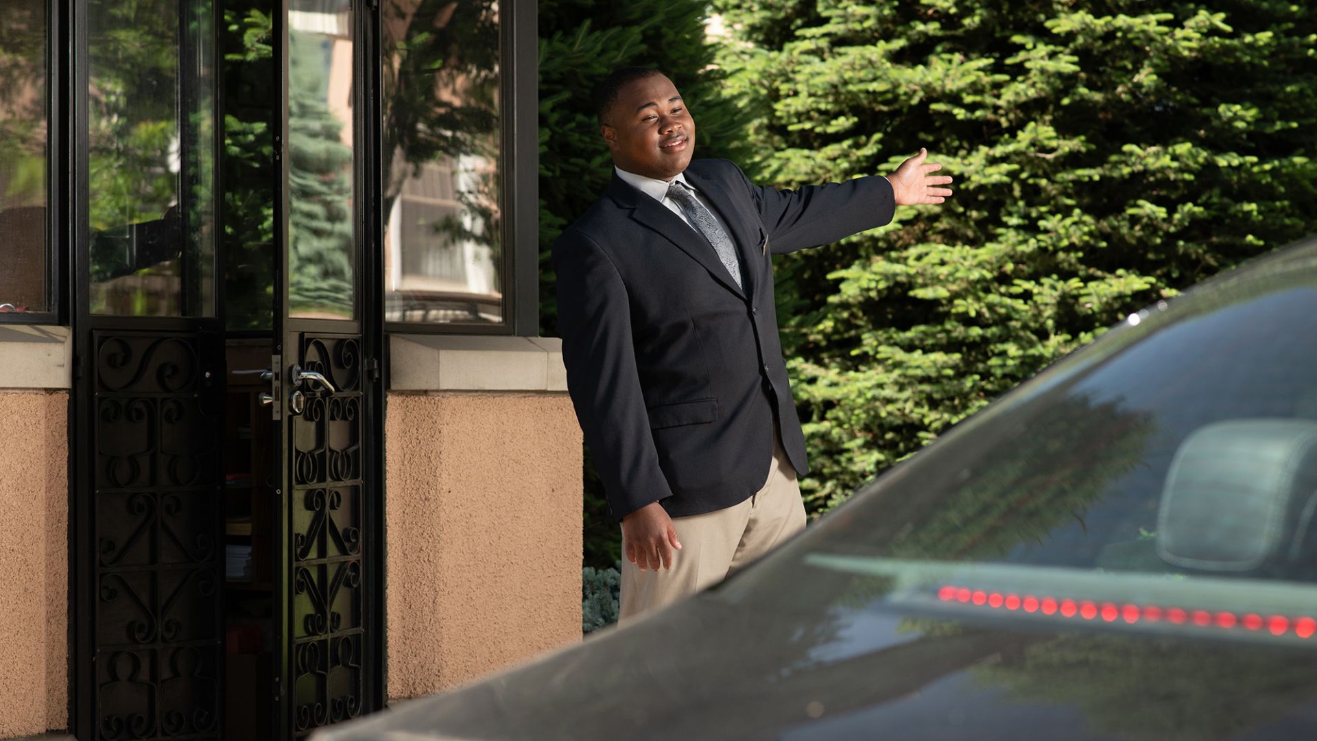 A Man Standing In Front Of A Car