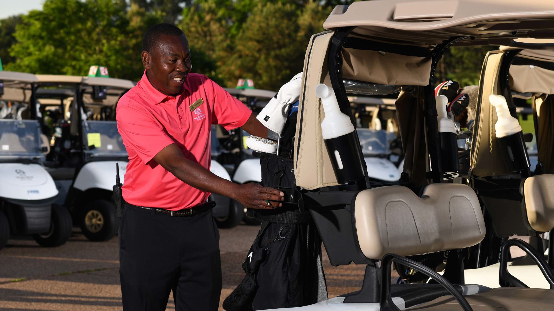 A Man Standing Next To A Golf Cart